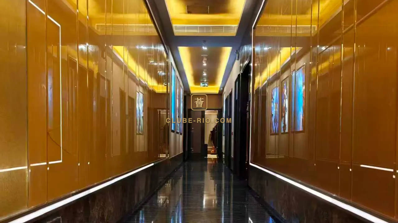 澳門KTV利澳薈包廂走廊，兩邊琥珀色鏡面牆掛著畫作，牆腳一條燈線貼著黑色雲石地面伸向盡頭